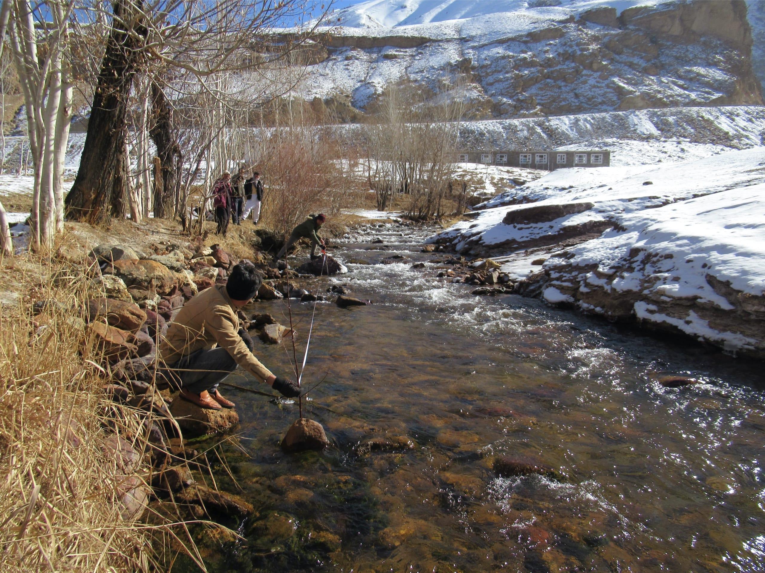 A man measures the velocity of the river flow